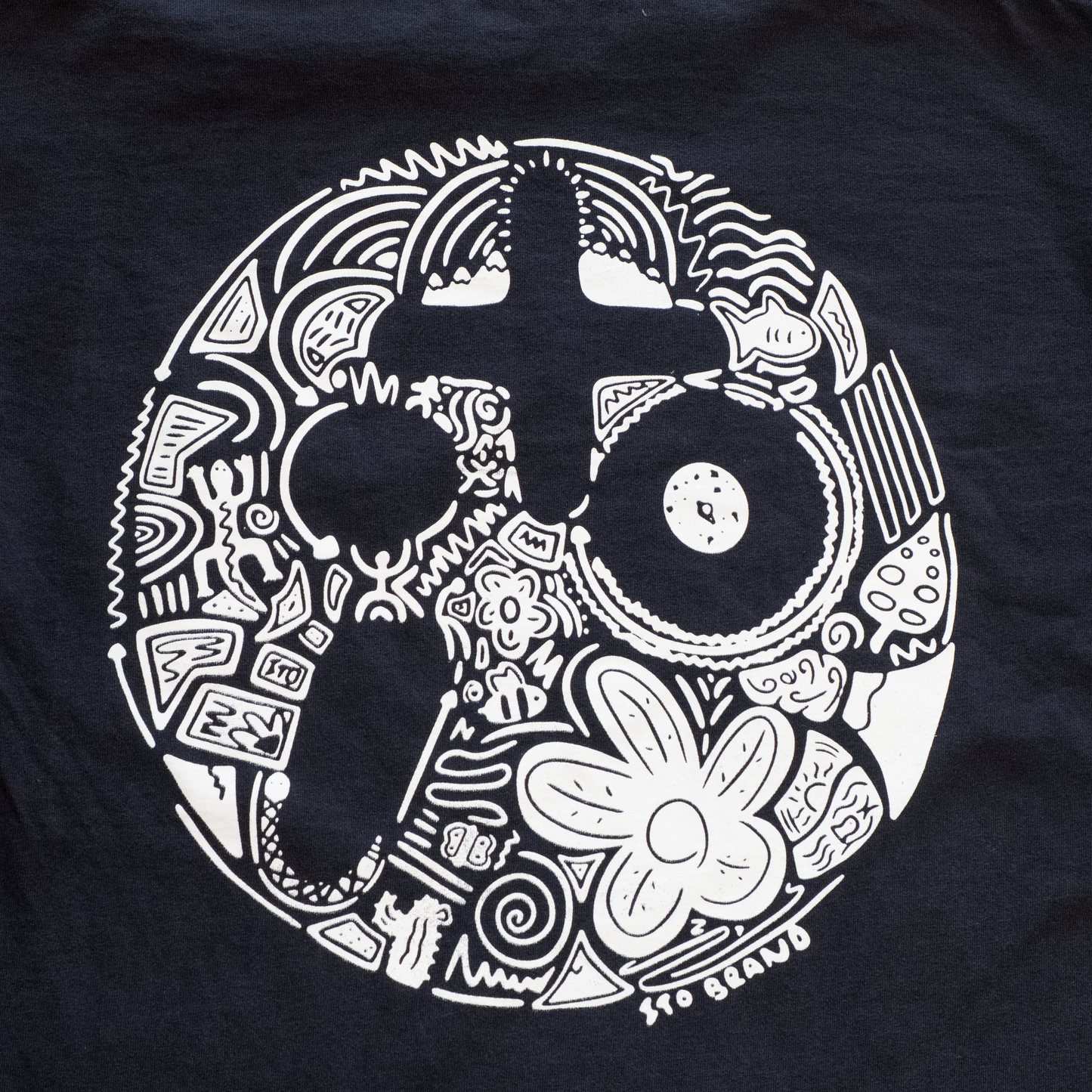 Black t-shirt with white intricate design on a plain background