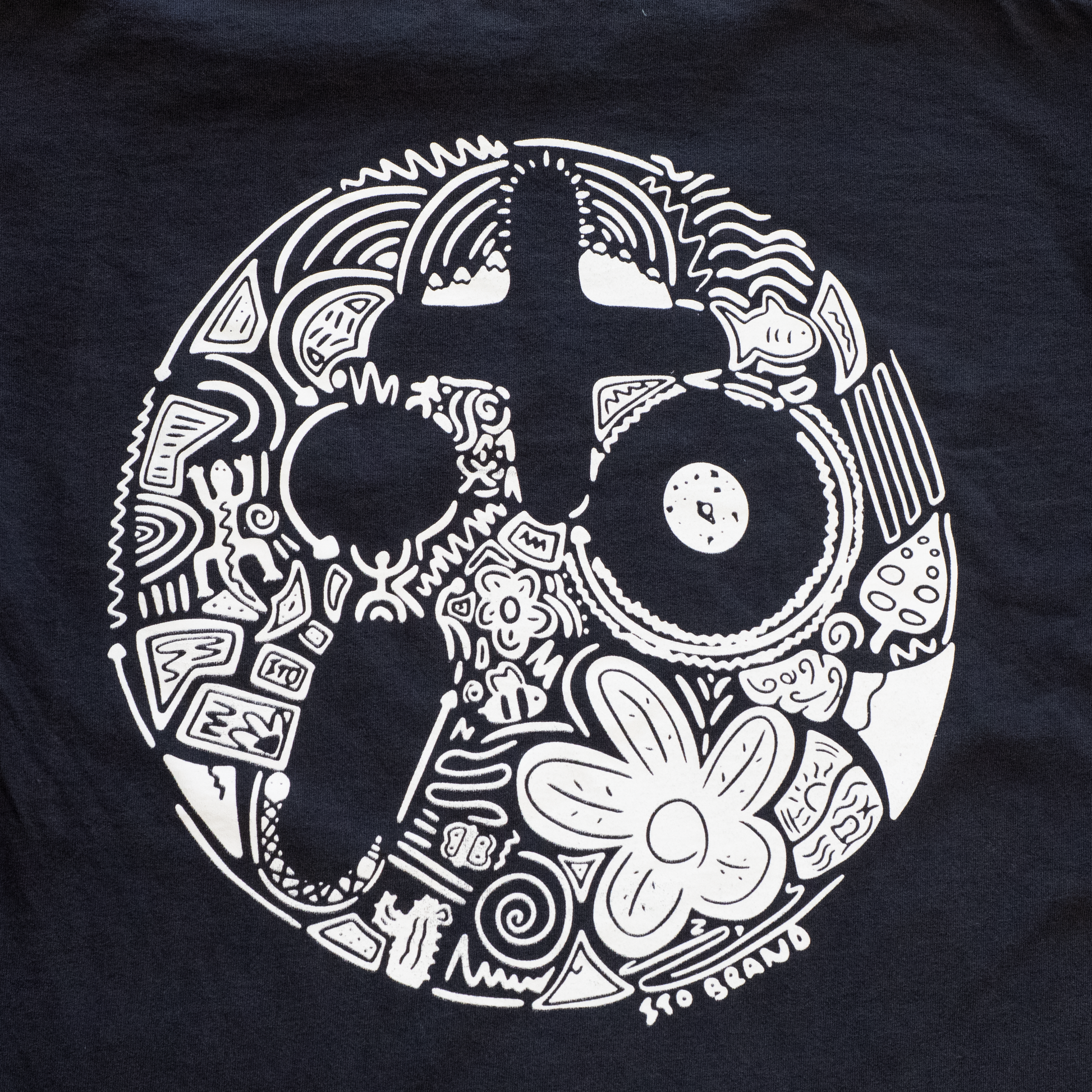 Black t-shirt with white intricate design on a plain background